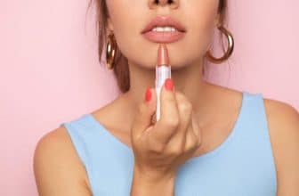 Junge hübsche Frau trägt Lippenstift auf